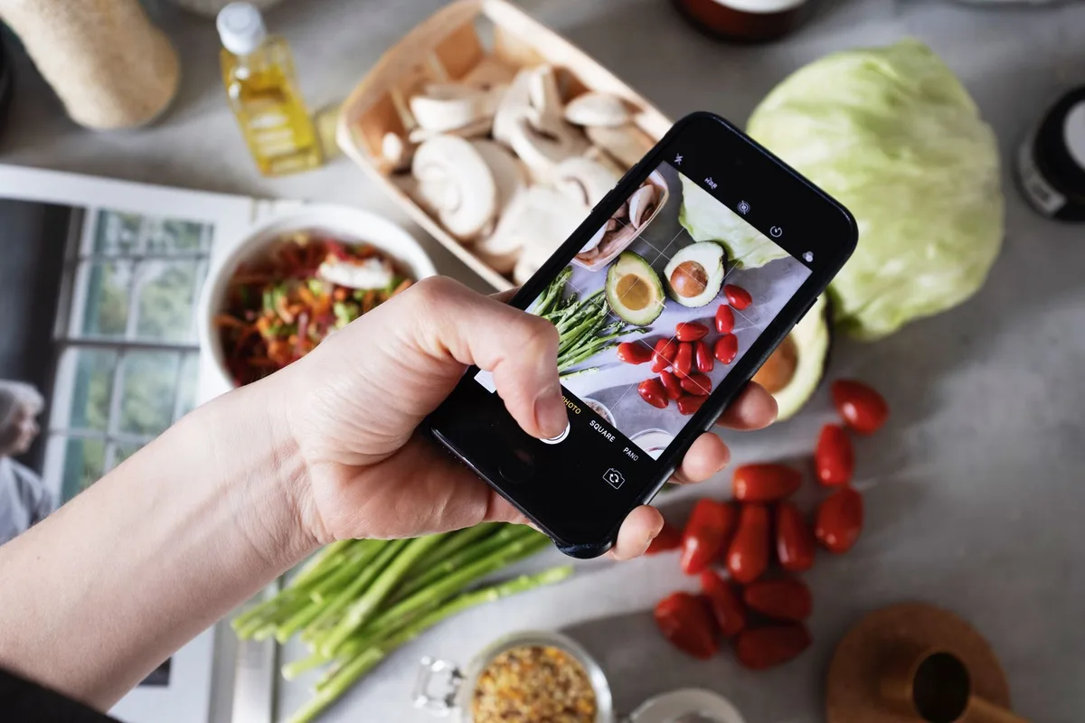 Telefoon fotografeert verse groente die op de werkbank ligt uitgestald
